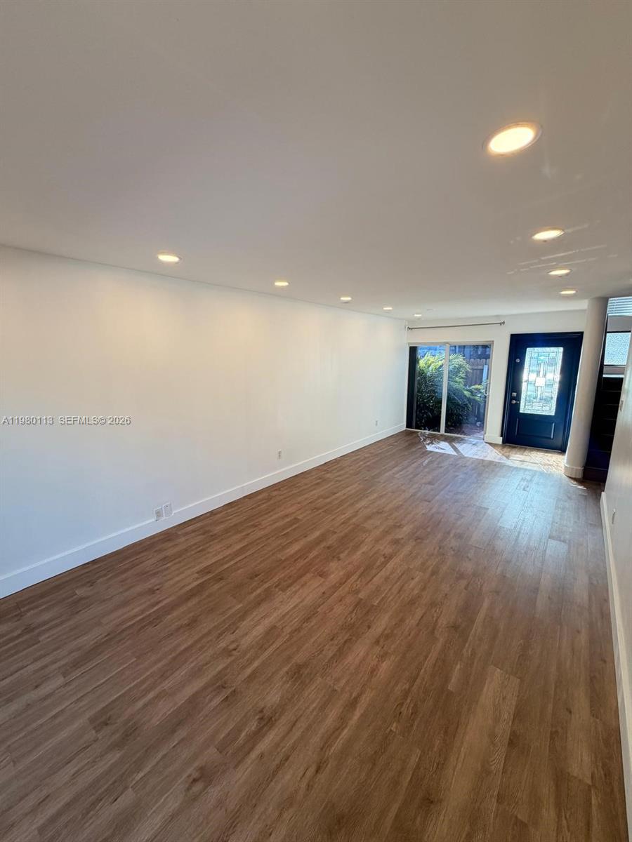 7101 Southwest 113th Court Miami, FL 33173 - Photo 5 of 30 a view of an empty room with wooden floor and a window