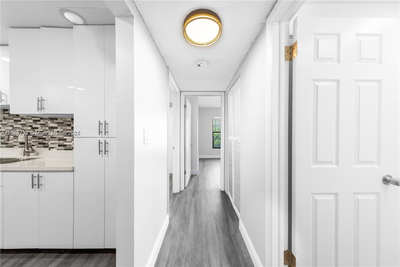 3680 Inverrary Drive, Unit 3J Lauderhill, FL 33319 - Photo 11 of 16 a view of a hallway with wooden floor and cabinet