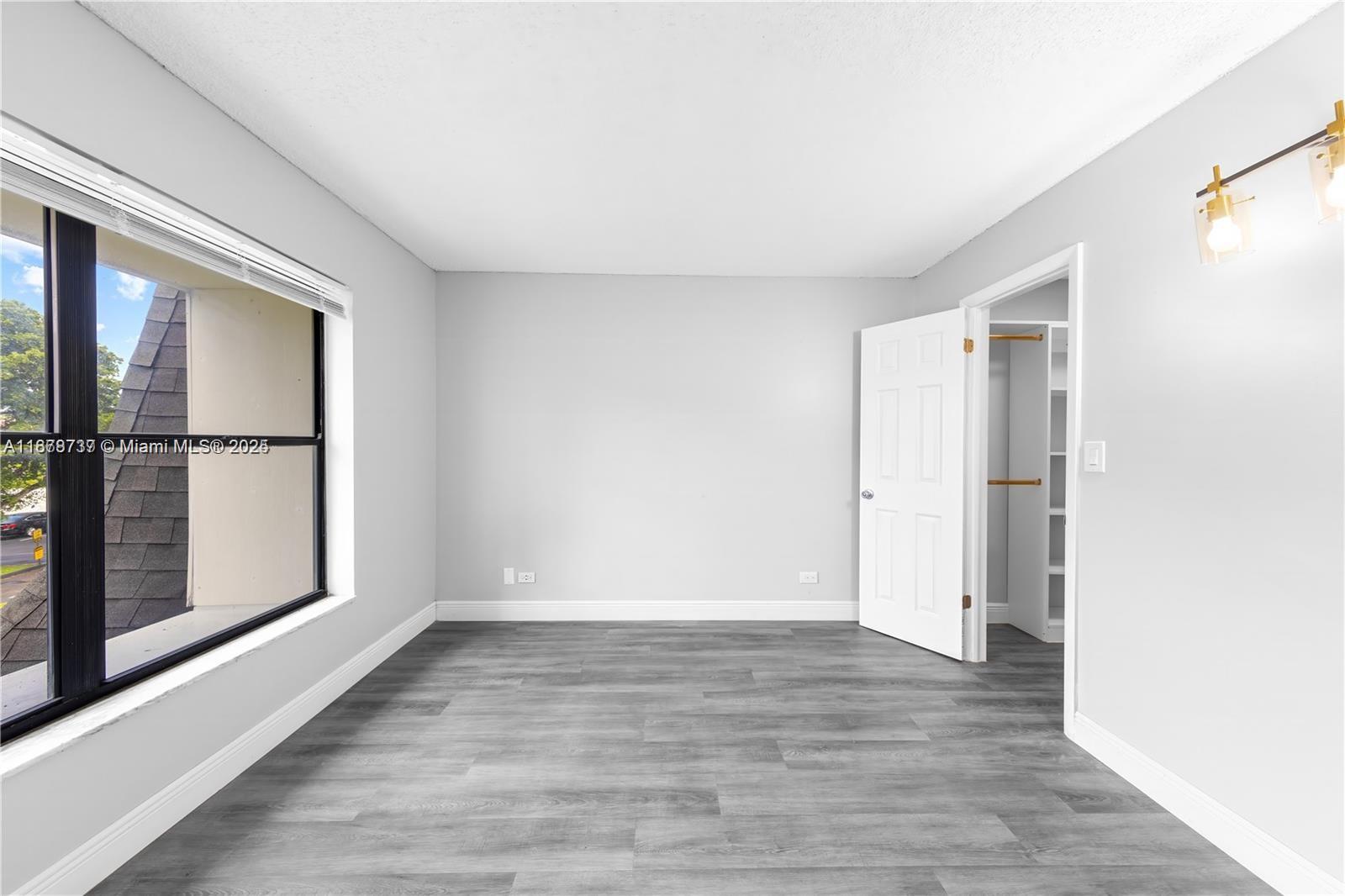 3680 Inverrary Drive, Unit 3J Lauderhill, FL 33319 - Photo 12 of 16 a view of an empty room with wooden floor and a window