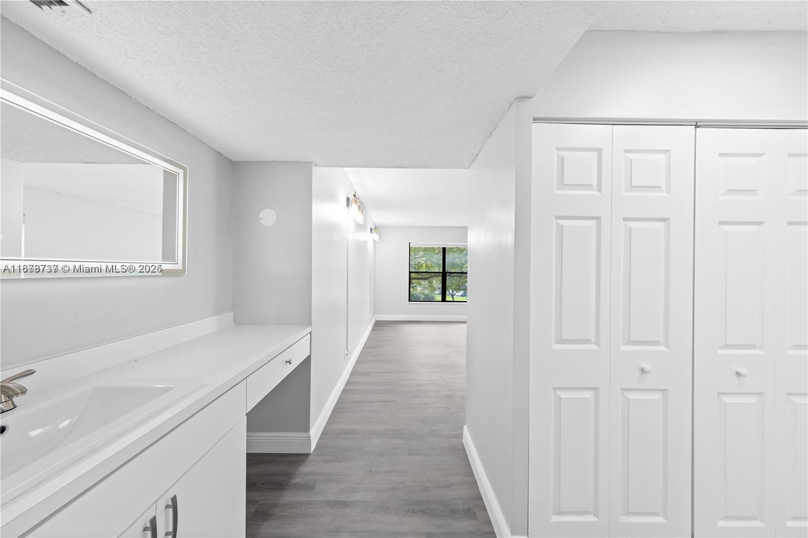 3680 Inverrary Drive, Unit 3J Lauderhill, FL 33319 - Photo 13 of 16 a view of a hallway with wooden floor and cabinet