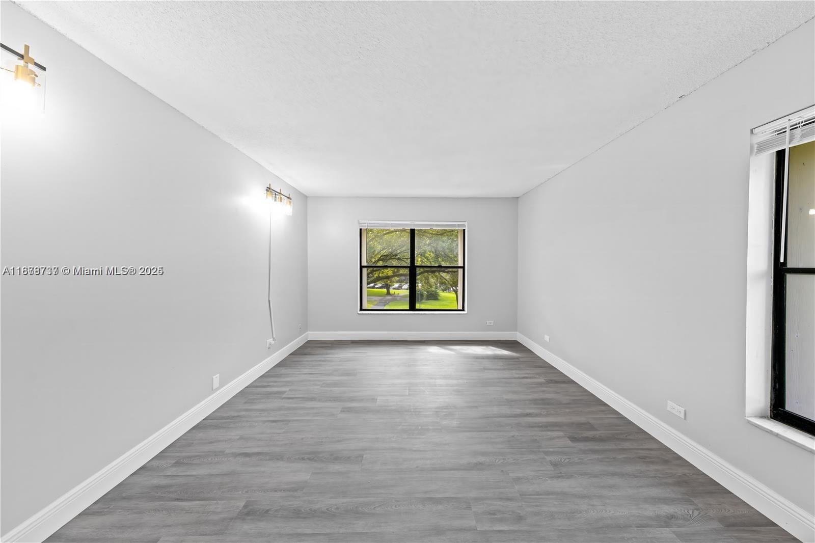 3680 Inverrary Drive, Unit 3J Lauderhill, FL 33319 - Photo 14 of 16 a view of an empty room with wooden floor and a window