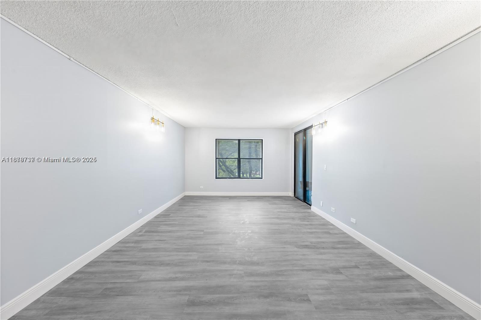 3680 Inverrary Drive, Unit 3J Lauderhill, FL 33319 - Photo 4 of 16 a view of an empty room with window and wooden floor