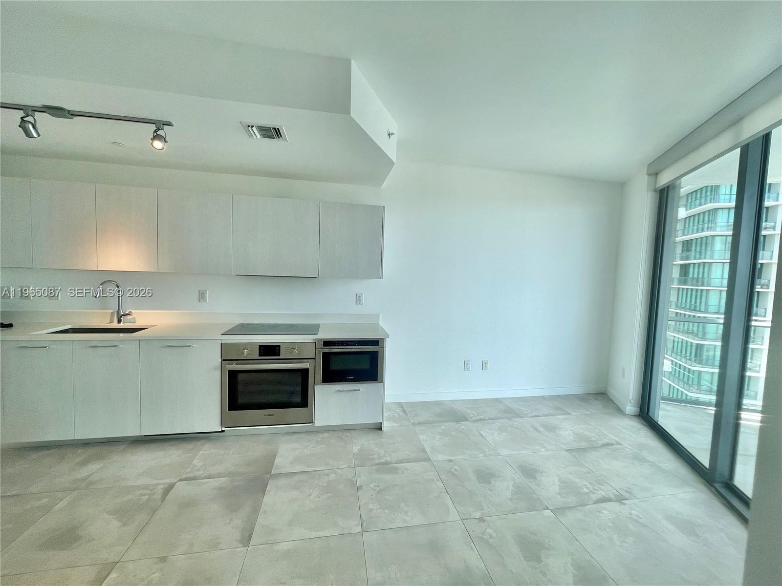 501 Northeast 31st Street, Unit 3007 Miami, FL 33137 - Photo 14 of 14 an empty room with kitchen and window