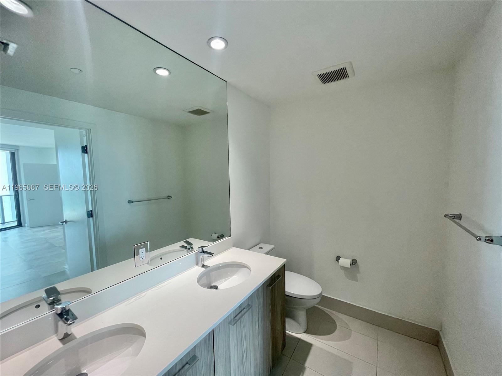 501 Northeast 31st Street, Unit 3007 Miami, FL 33137 - Photo 9 of 14 a bathroom with a sink and mirror with toilet