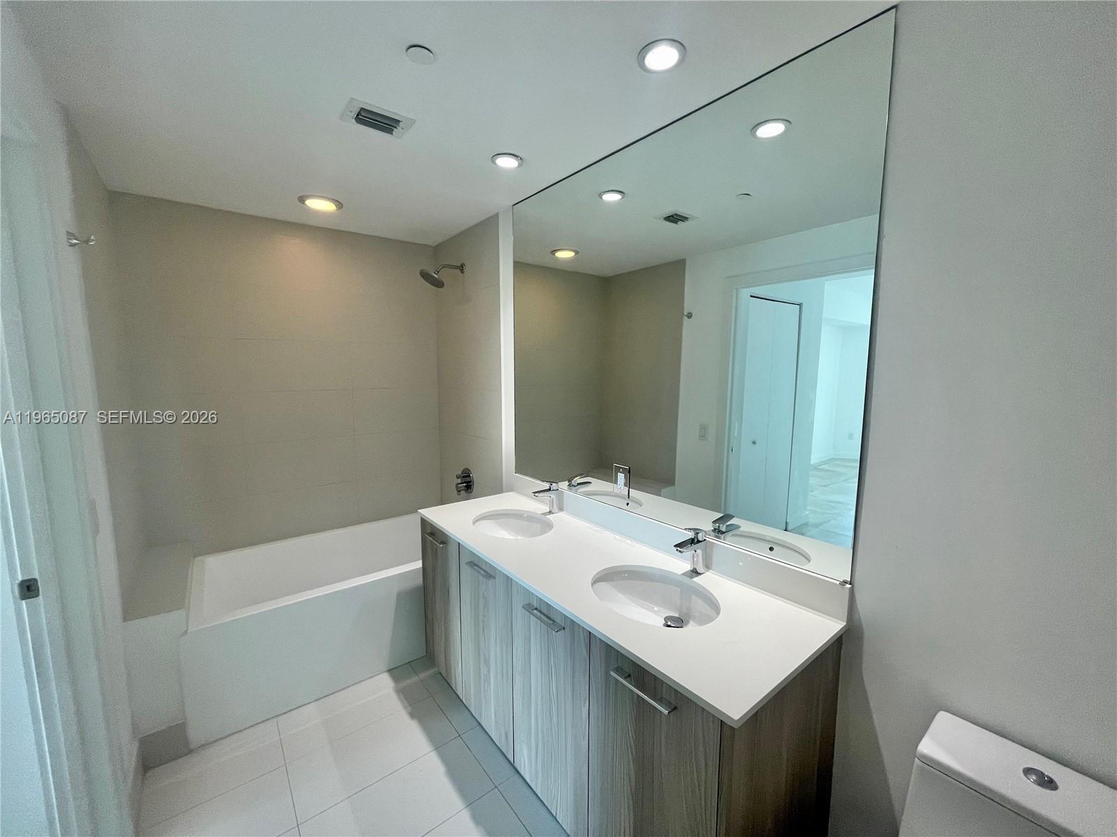 501 Northeast 31st Street, Unit 3007 Miami, FL 33137 - Photo 10 of 14 a bathroom with a sink vanity tub and shower