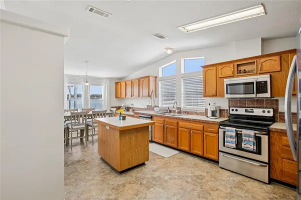 a kitchen with stainless steel appliances a stove a sink and a refrigerator