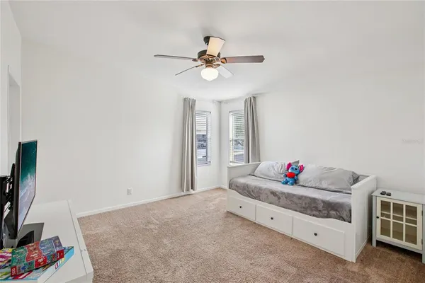 a living room with furniture and a ceiling fan