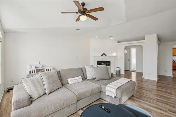 a living room with furniture hard wood floor and a ceiling fan