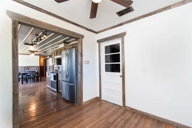 a view of a livingroom with wooden floor and a ceiling fan