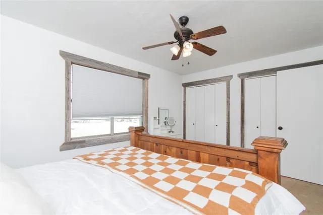 a bedroom with a bed and a window