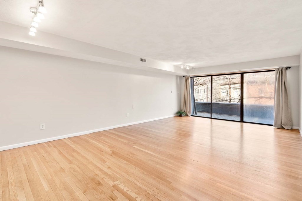 120 Beaconsfield Road, Unit 9 Brookline, MA 02445 - Photo 5 of 20 a view of an empty room with wooden floor and a window