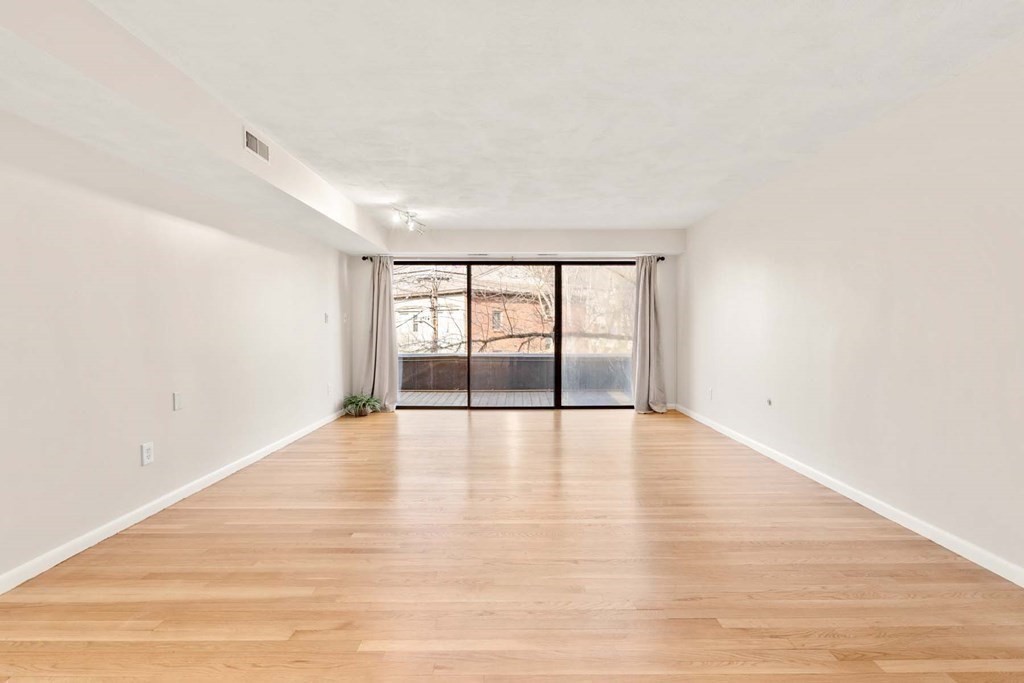 120 Beaconsfield Road, Unit 9 Brookline, MA 02445 - Photo 6 of 20 a view of an empty room with wooden floor and a window