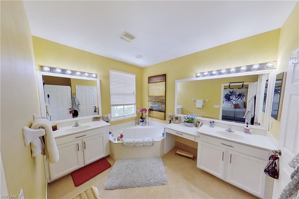 3970 Cherrybrook Loop Fort Myers, FL 33966 - Photo 14 of 21 a spacious bathroom with a double vanity sink a mirror and a bathtub