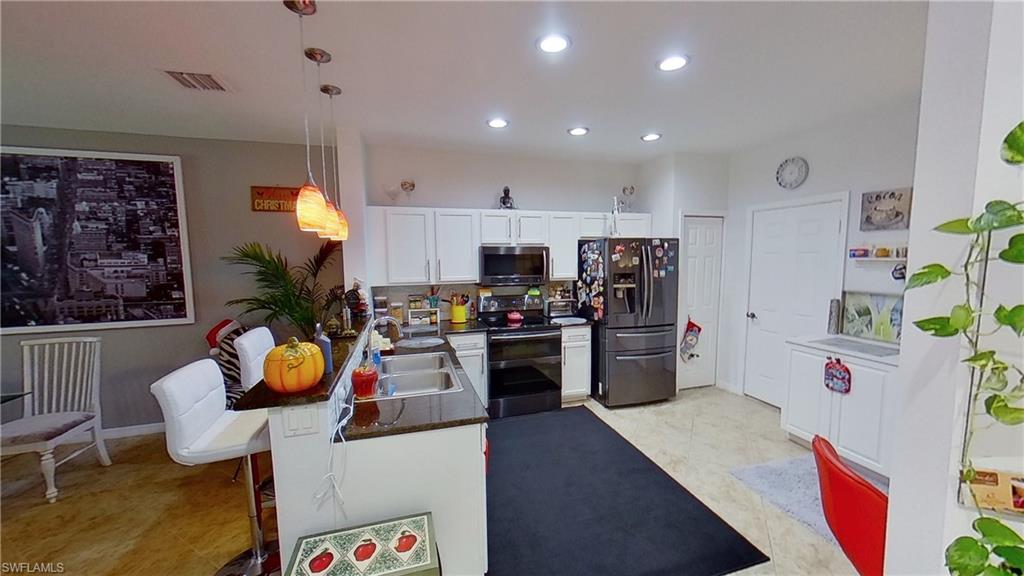 3970 Cherrybrook Loop Fort Myers, FL 33966 - Photo 4 of 21 a kitchen that has a lot of cabinets a sink and appliances
