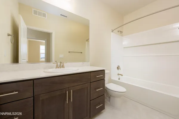 a bathroom with a sink a toilet a mirror and shower