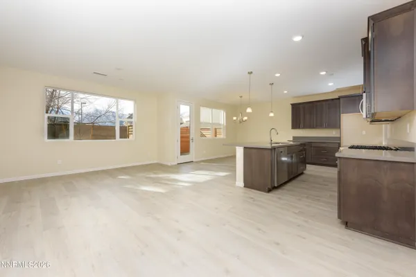 a large kitchen with stainless steel appliances granite countertop a stove a sink and a microwave