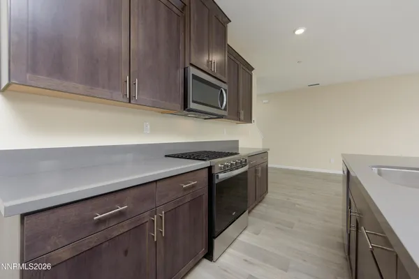a kitchen with granite countertop cabinets stainless steel appliances and wooden floor