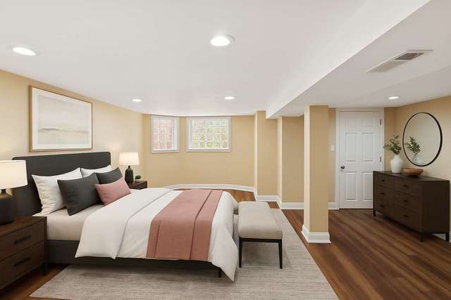 642 East 90th Street Chicago, IL 60619 - Photo 11 of 13 a bedroom with a large bed and wooden floor