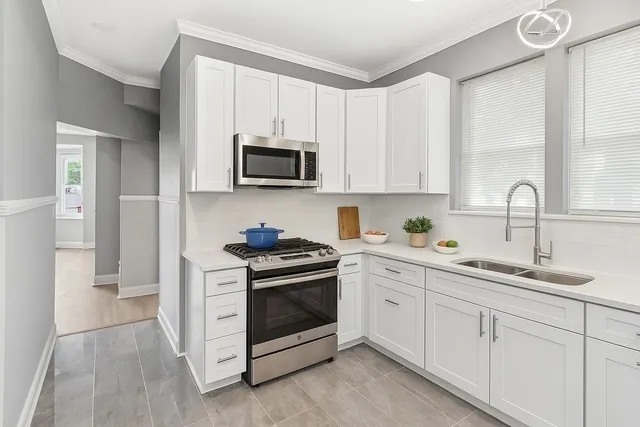 a kitchen with white cabinets and stainless steel appliances