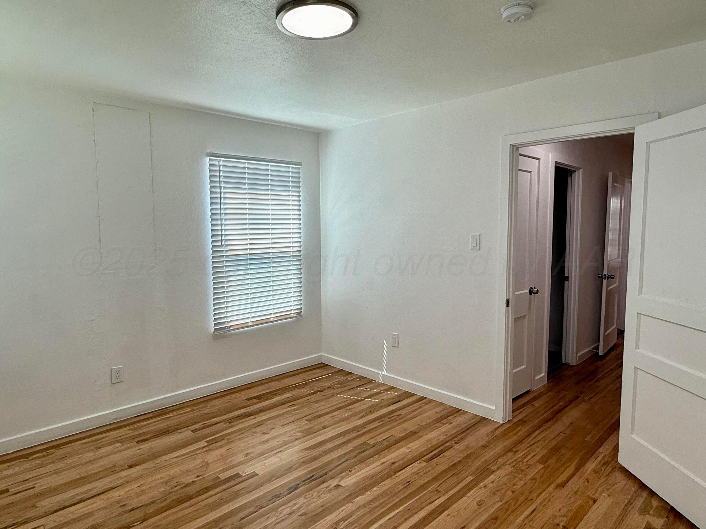1303 Boyd Street Borger, TX 79007 - Photo 15 of 19 a view of empty room with wooden floor and fan