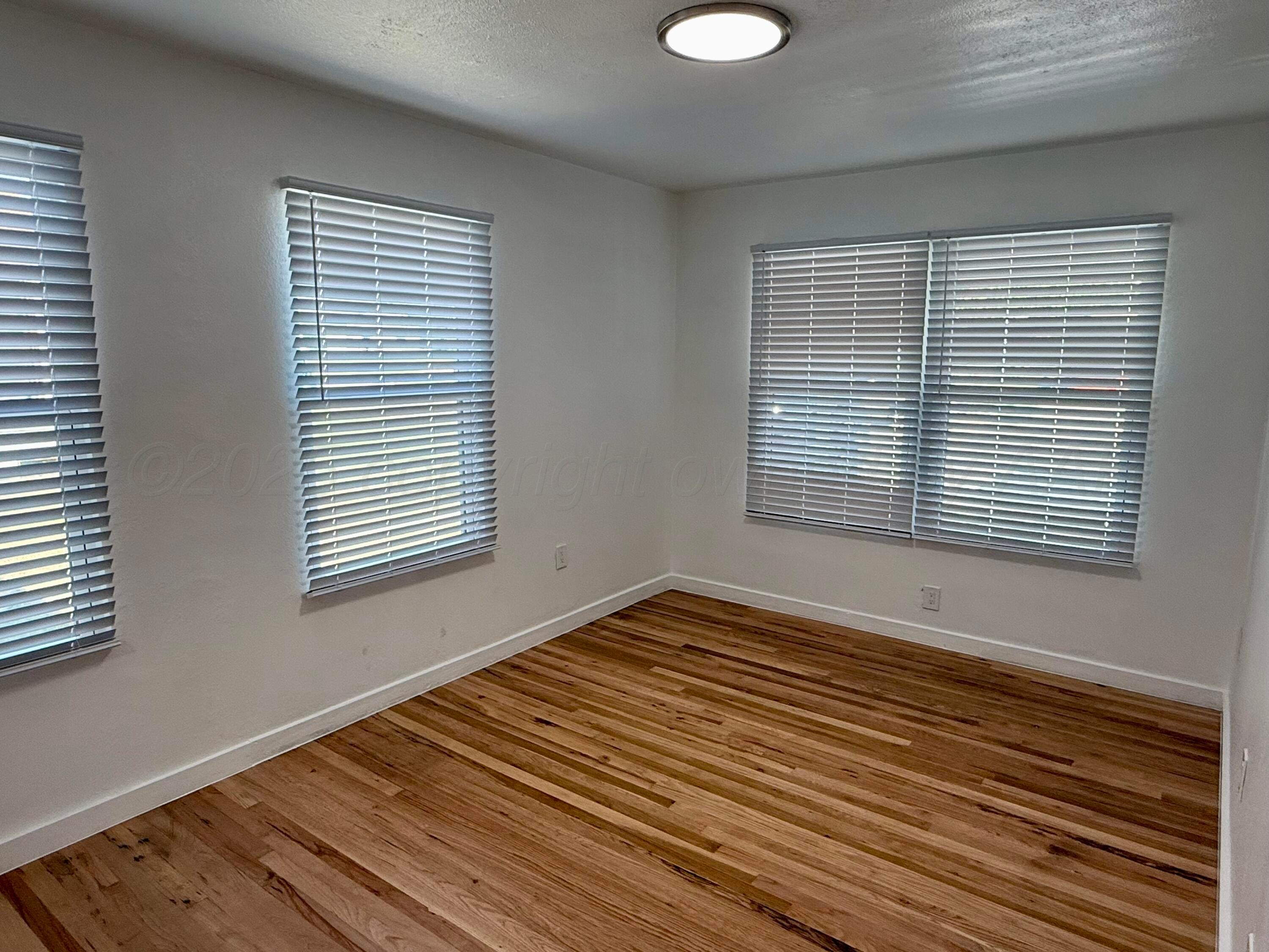 1303 Boyd Street Borger, TX 79007 - Photo 16 of 19 a view of a room with wooden floor and a window
