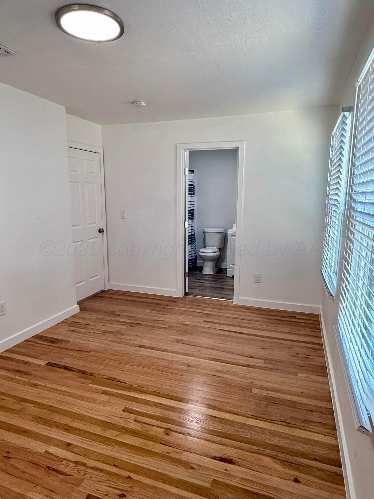 1303 Boyd Street Borger, TX 79007 - Photo 17 of 19 a view of empty room with wooden floor and fan