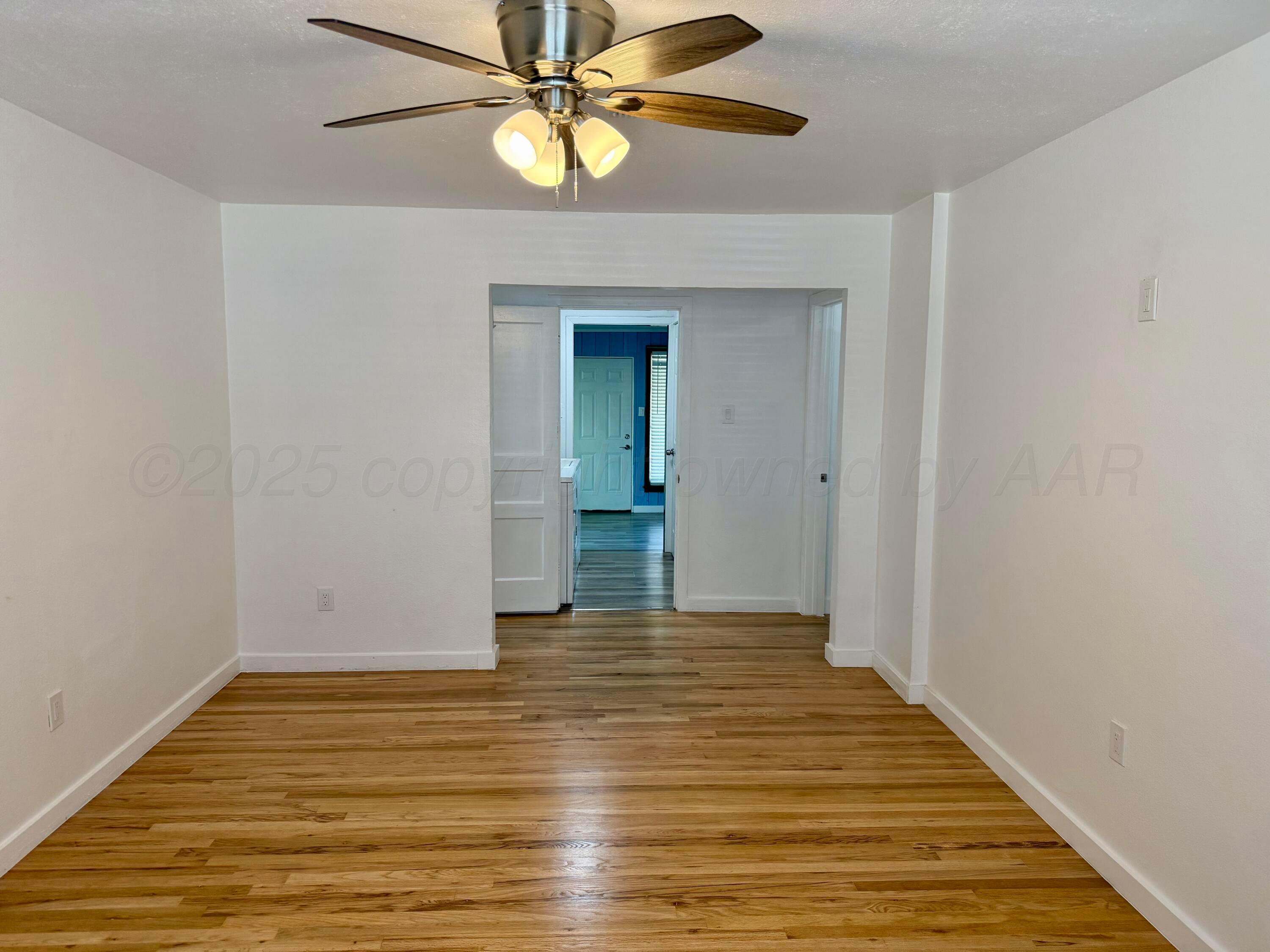 1303 Boyd Street Borger, TX 79007 - Photo 3 of 19 a view of an empty room with wooden floor