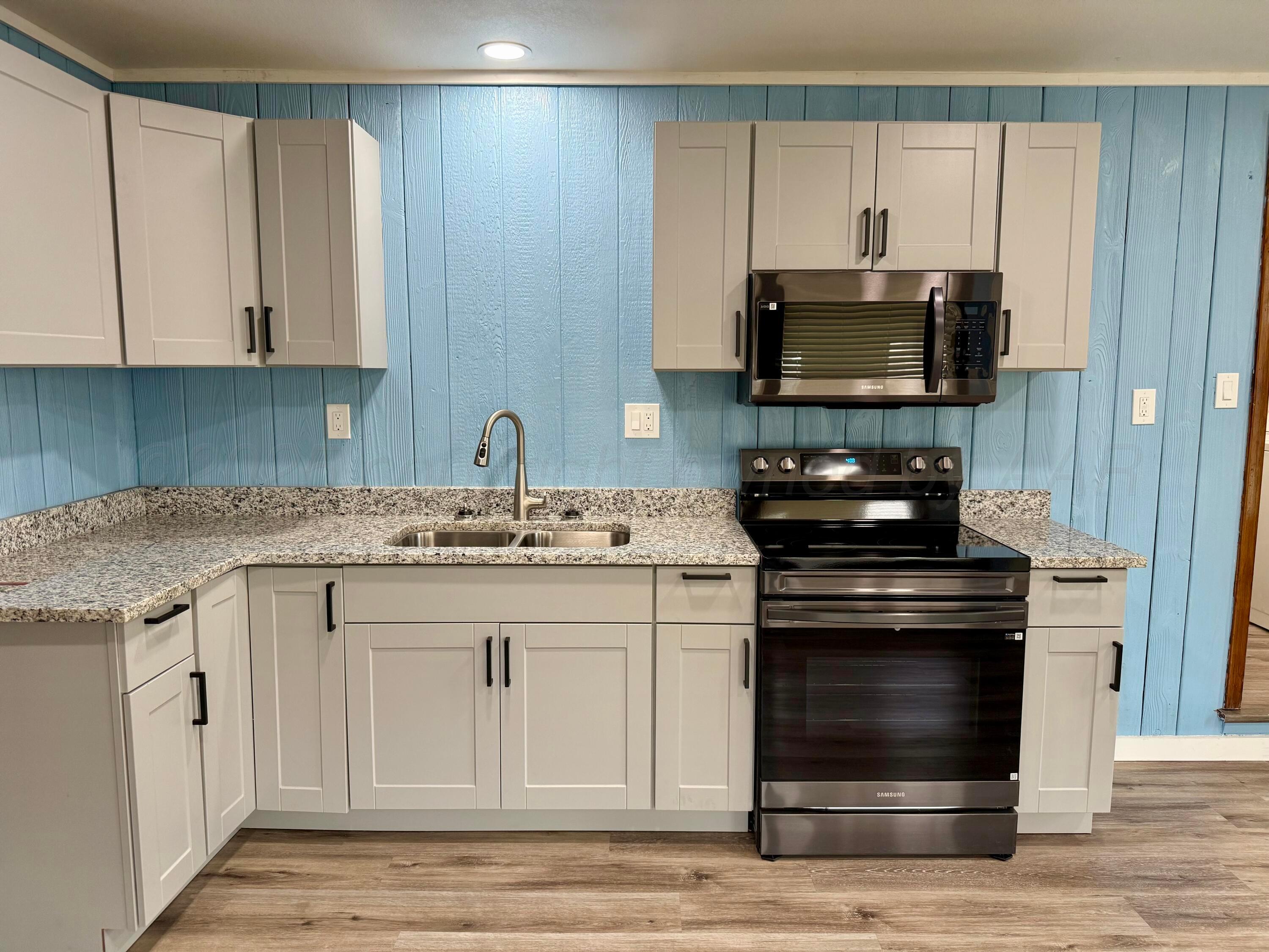 1303 Boyd Street Borger, TX 79007 - Photo 6 of 19 a kitchen with white cabinets and a stove
