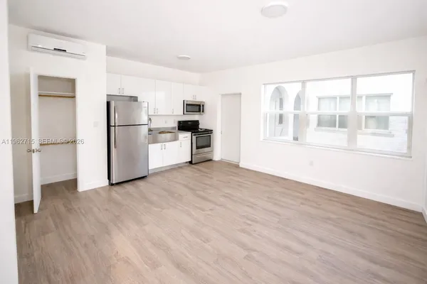 a view of a kitchen with a refrigerator a stove top oven and cabinets