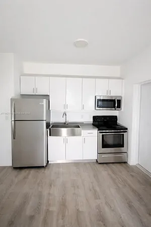 a kitchen with a refrigerator and a stove