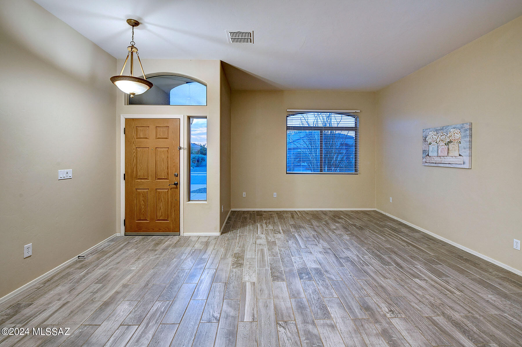 15084 North Pelham Road Tucson, AZ 85739 - Photo 7 of 40 an empty room with wooden floor cabinet and windows