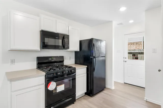 a kitchen with stainless steel appliances granite countertop a sink stove and wooden floor