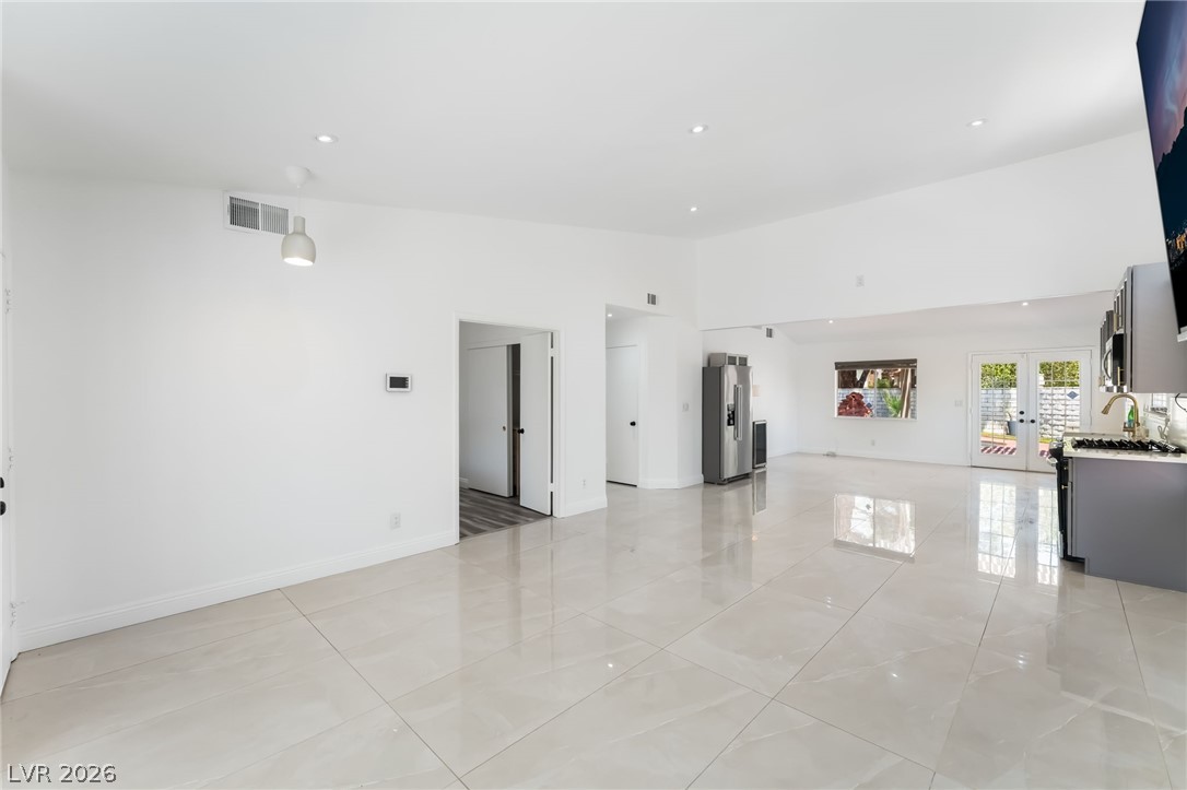 9028 Cypress Point Road Las Vegas, NV 89117 - Photo 8 of 39 A spacious, open-concept interior features gleaming tile flooring and ample natural illumination from the windows and French doors.