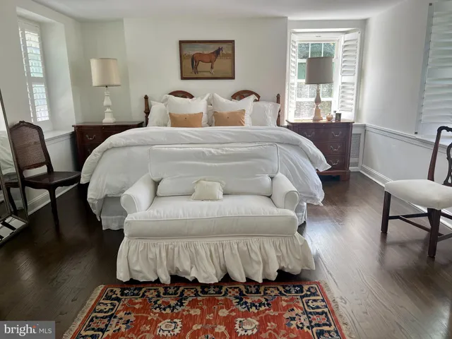 a bed sitting in a bedroom next to a window with wooden floor