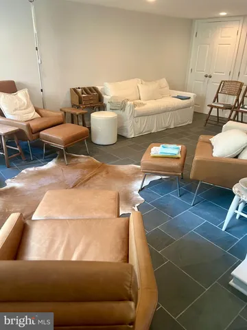 a living room with furniture a rug and white walls