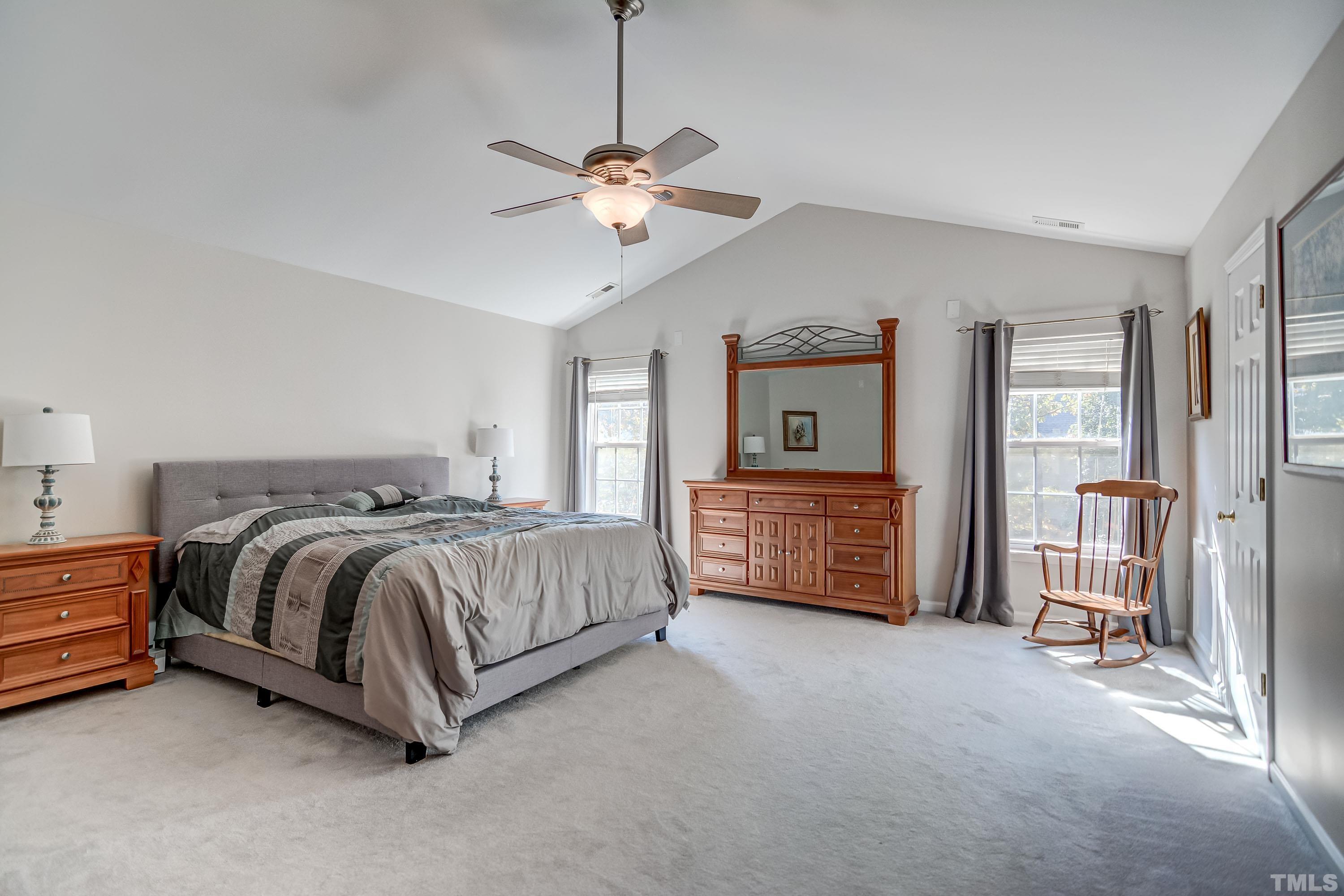 5424 Neuse Forest Road Raleigh, NC 27616 - Photo 15 of 30 a spacious bedroom with a bed a dresser and a chandelier