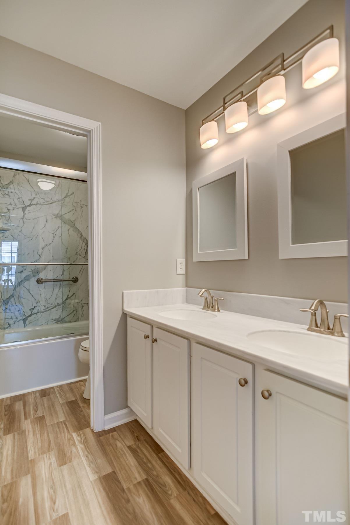 5424 Neuse Forest Road Raleigh, NC 27616 - Photo 22 of 30 a bathroom with a double vanity sink and mirror with bathtub