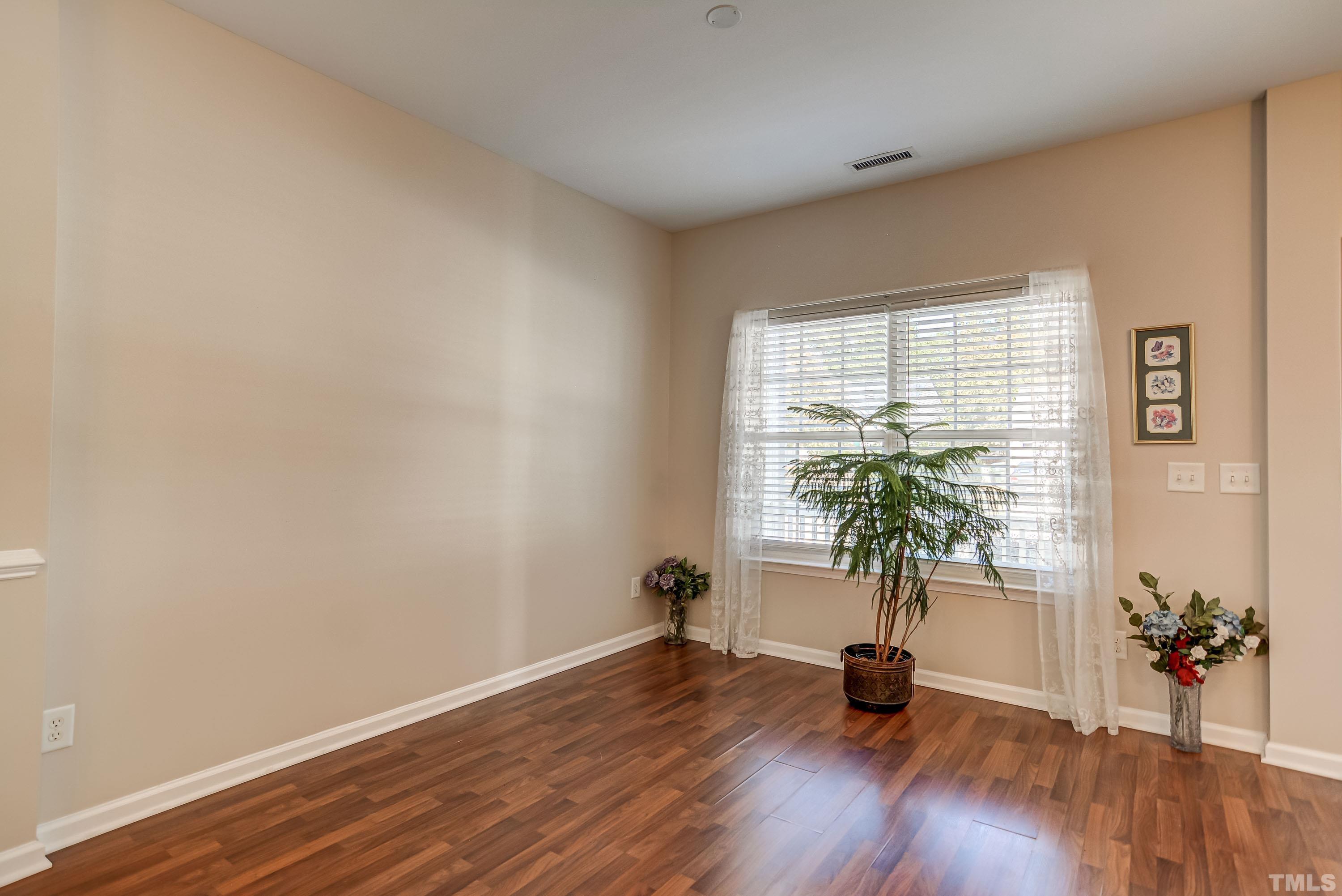 5424 Neuse Forest Road Raleigh, NC 27616 - Photo 5 of 30 a view of an empty room with a window and wooden floor
