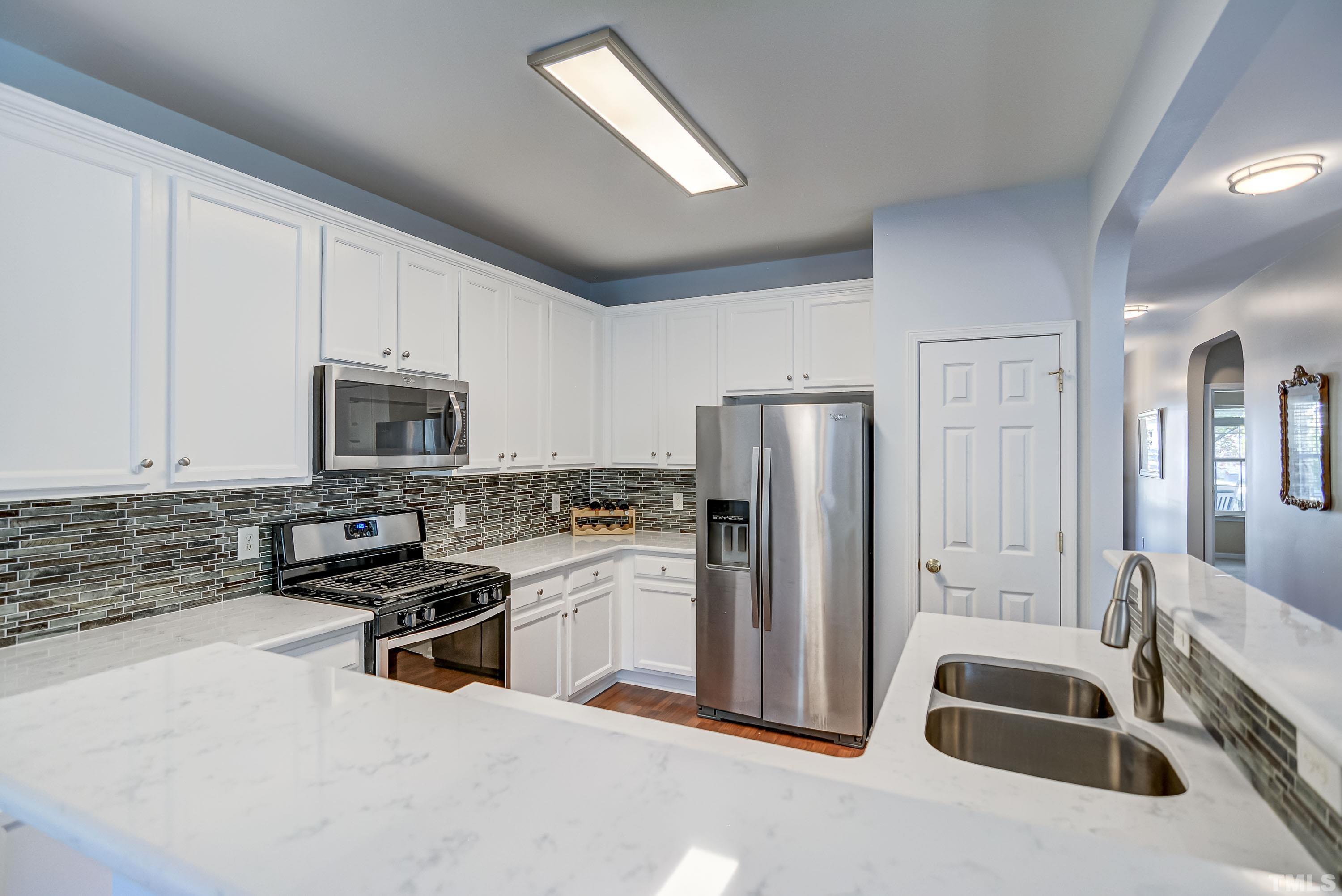 5424 Neuse Forest Road Raleigh, NC 27616 - Photo 8 of 30 a kitchen with stainless steel appliances granite countertop a refrigerator a stove a sink and white cabinets