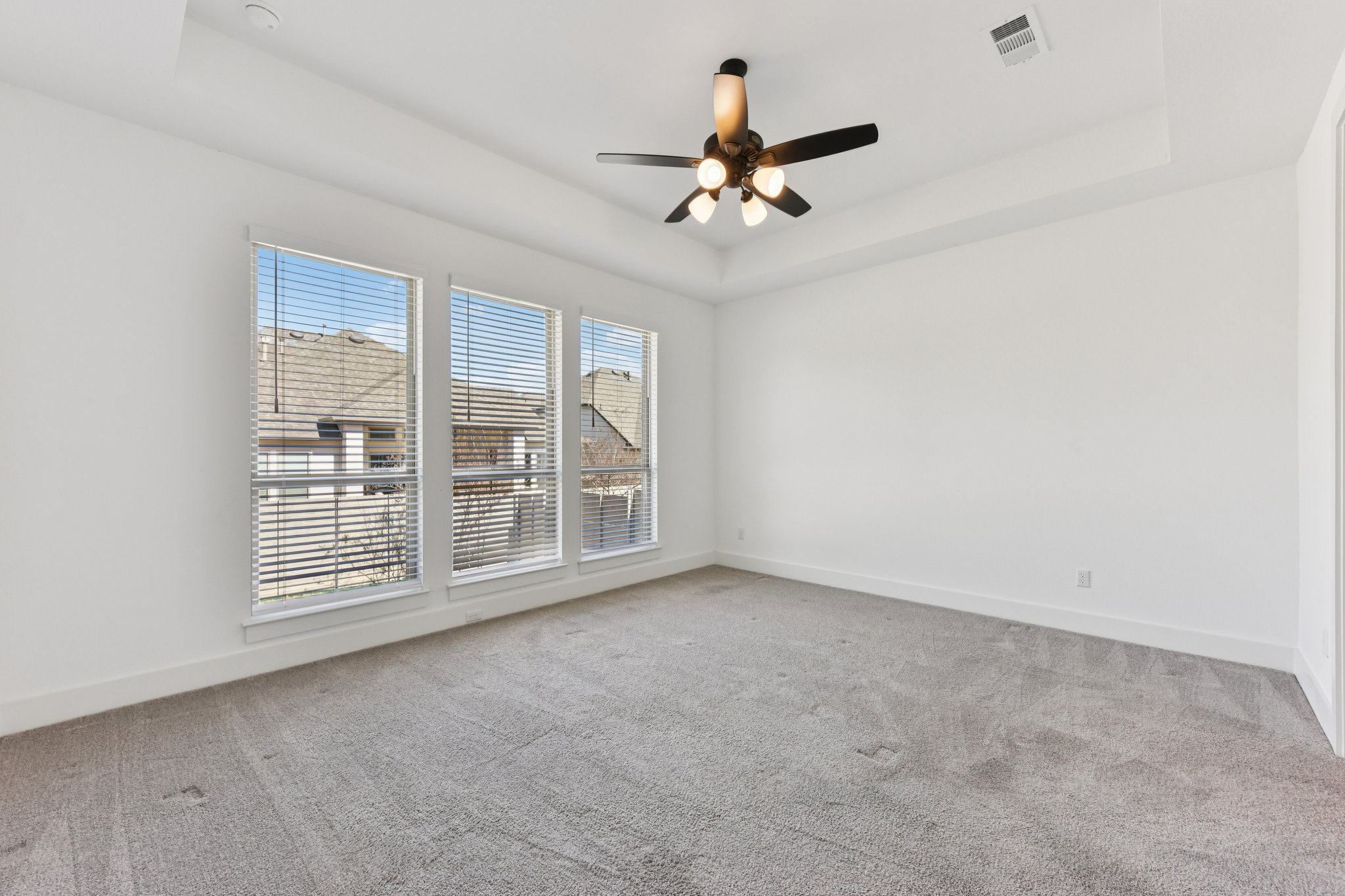 225 Ashmore Lane Georgetown, TX 78628 - Photo 12 of 36 Main floor primary bedroom large enough for your king size bed. Love the tray ceiling, ceiling fan and large picture windows