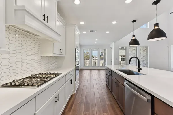 a kitchen with a sink a stove a microwave and cabinets