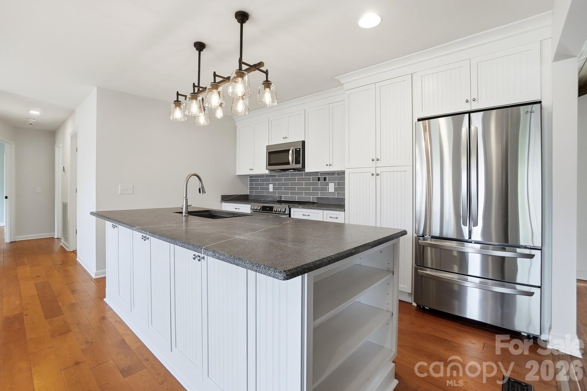 2295 Sussex Road York, SC 29745 - Photo 11 of 47 a kitchen with kitchen island a counter top space wooden floor and stainless steel appliances