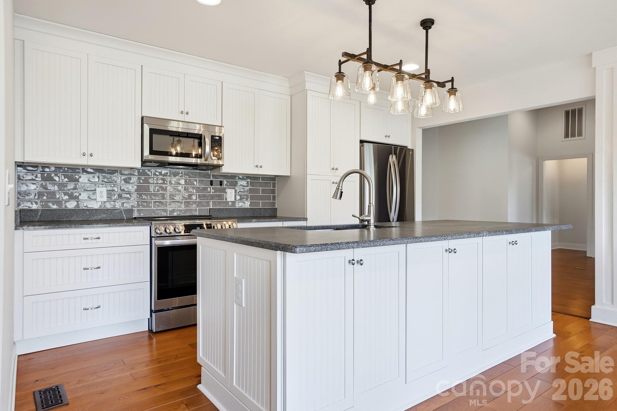 2295 Sussex Road York, SC 29745 - Photo 13 of 47 a kitchen with granite countertop white cabinets and stainless steel appliances