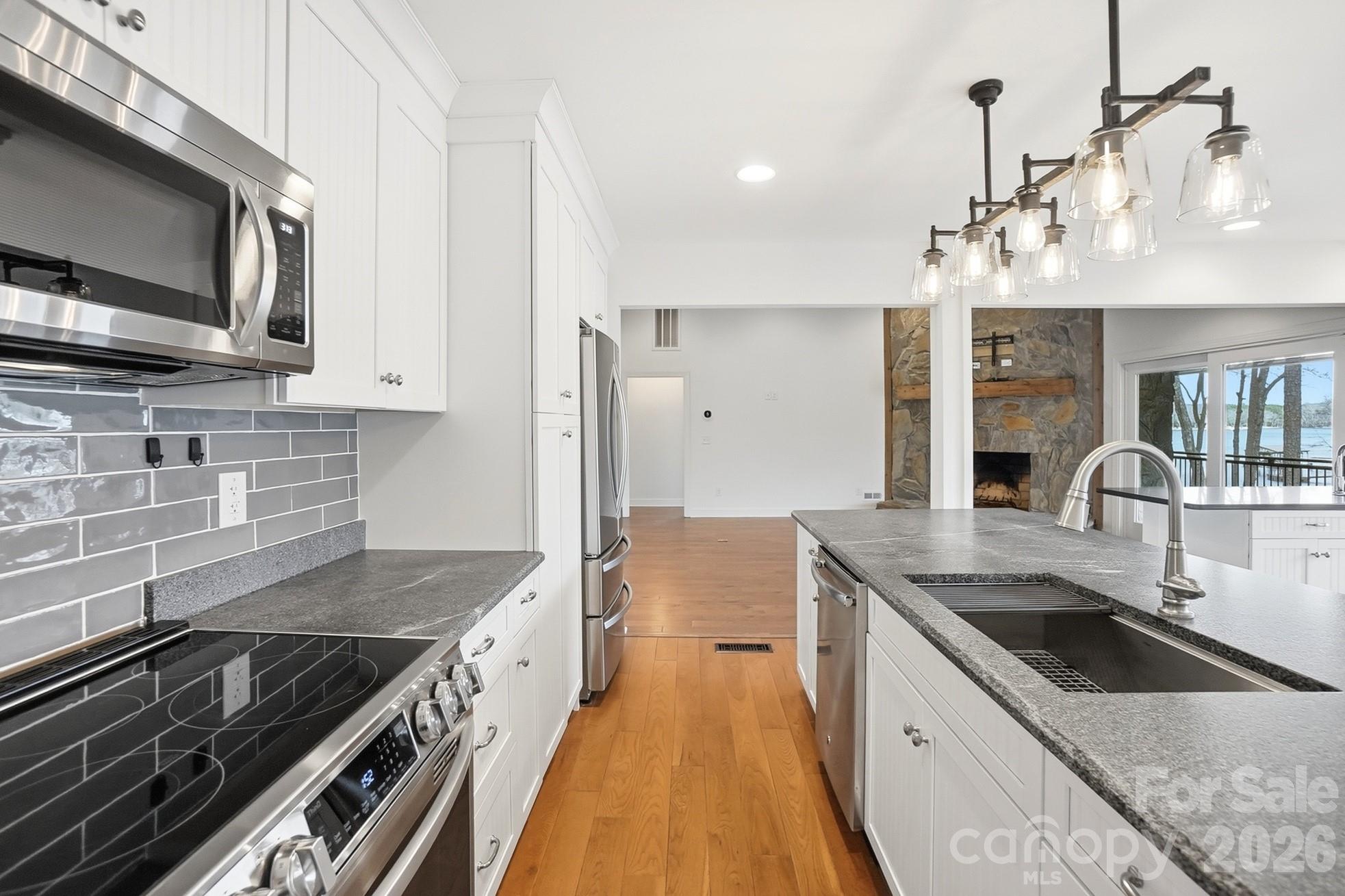 2295 Sussex Road York, SC 29745 - Photo 14 of 47 a kitchen with granite countertop a sink dishwasher stove and oven with wooden floor