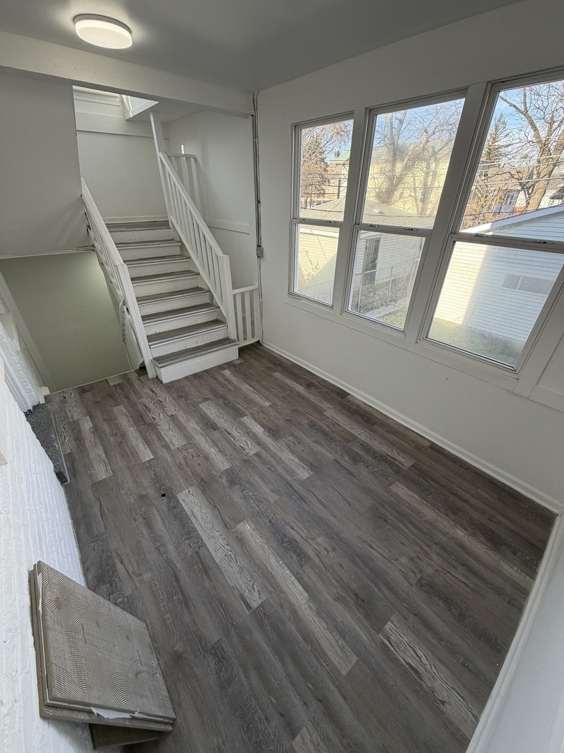 1048 West Marquette Road, Unit 1 Chicago, IL 60621 - Photo 11 of 13 a view of an empty room with stairs and a window