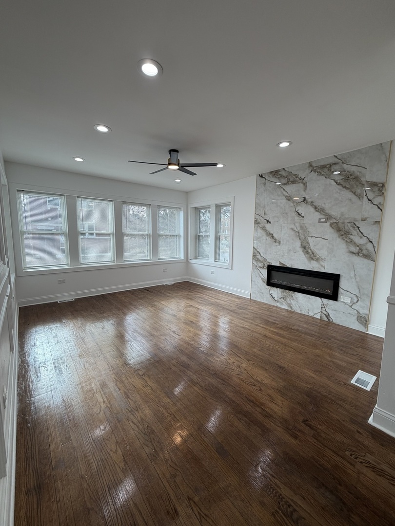1048 West Marquette Road, Unit 1 Chicago, IL 60621 - Photo 2 of 13 an empty room with wooden floor and windows