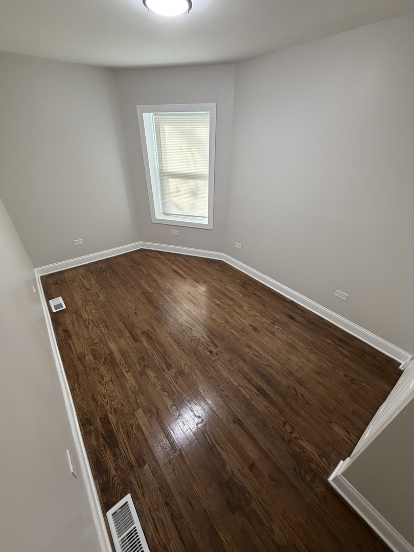 1048 West Marquette Road, Unit 1 Chicago, IL 60621 - Photo 5 of 13 an empty room with wooden floor
