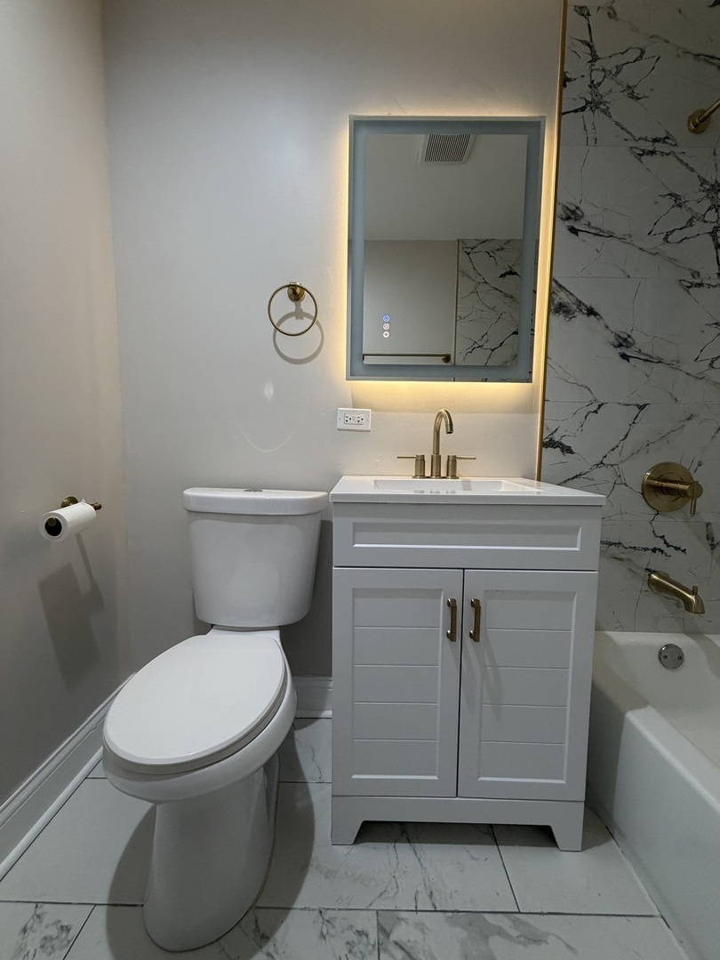 1048 West Marquette Road, Unit 1 Chicago, IL 60621 - Photo 7 of 13 a bathroom with a toilet sink and mirror