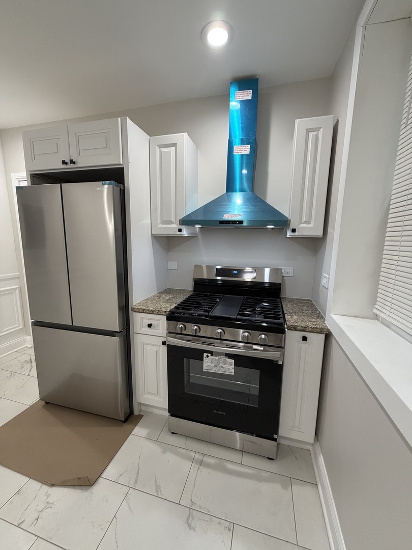 1048 West Marquette Road, Unit 1 Chicago, IL 60621 - Photo 8 of 13 a kitchen with a stove and a refrigerator