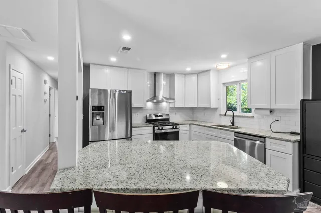 a kitchen with stainless steel appliances granite countertop a sink stove and refrigerator